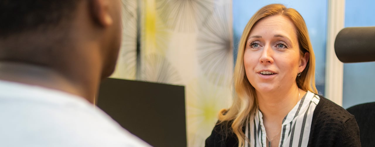 En medarbetare i samtal med en ungdom.