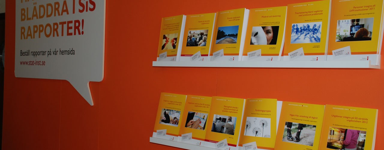 SiS-rapporter med gult omslag mot en orange vägg