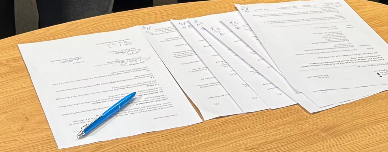 Bild på dokument och en penna som ligger på ett bord.