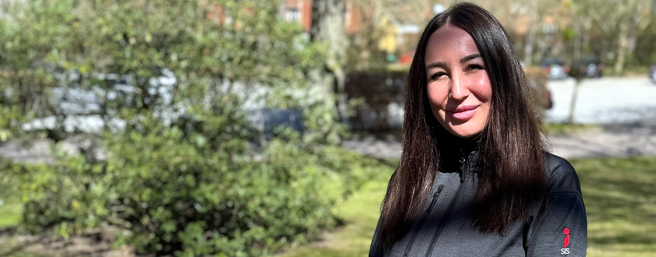 Bild på gruppledare Elma när hon står utomhus i grönskan.