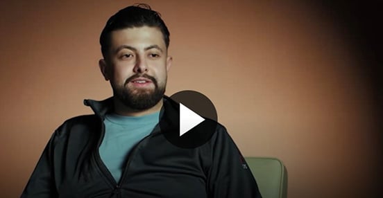 Bildklipp från en film där behandlingspedagog Hussien sitter i en stol och berättar om sin vardag på SiS.