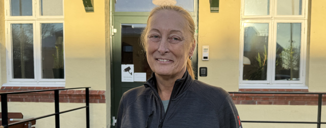 Bild på behandlingspedagogen Vanja som står framför ett gult hus.