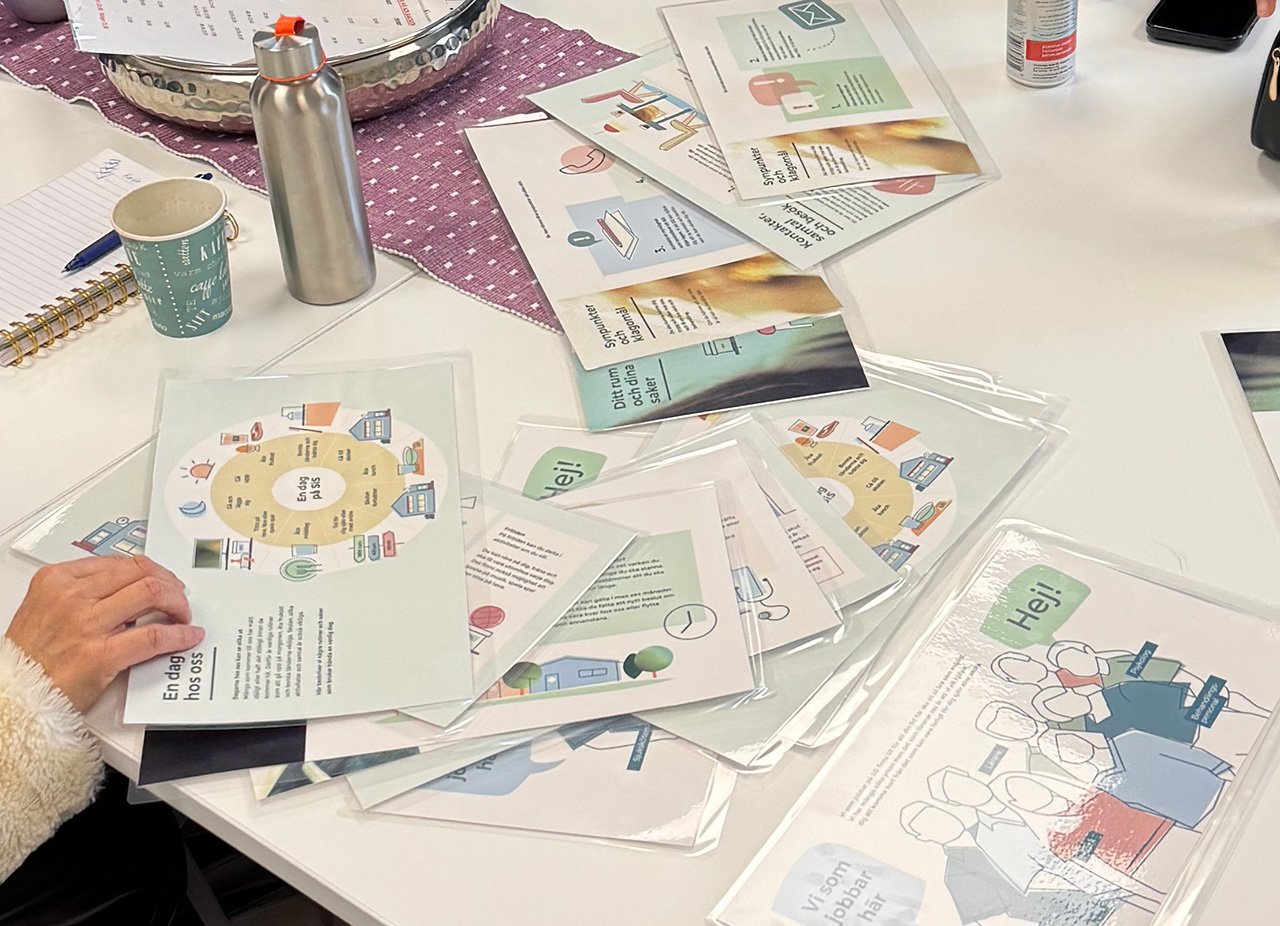 En medarbetare bläddrar i bildstödsmaterialet som ligger på ett bord.