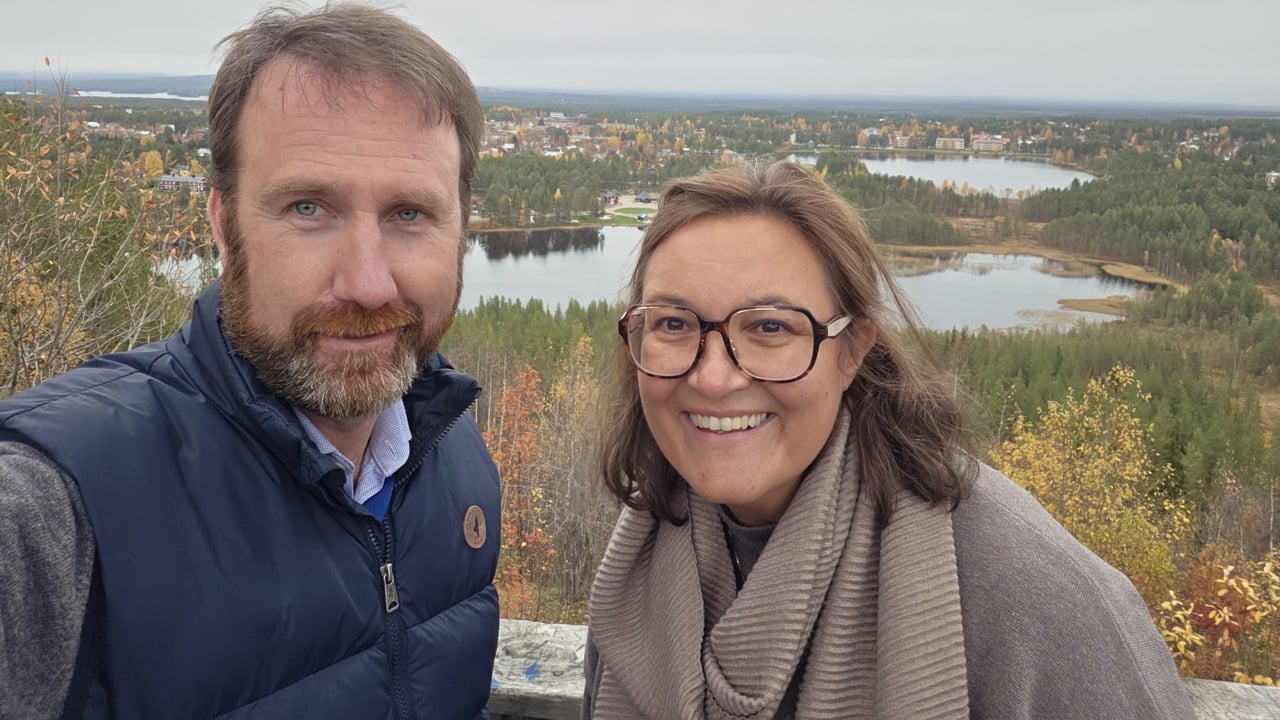 Två personer tar en bild ihop med vackert landskap i bakgrunden.